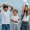 Enfants jouant avec le Lapin Méloé blanc 37 cm Maïlou Tradition à la plage