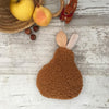 Bouillotte sèche en forme de poire - Moumooute Cognac | Bouillotte naturelle en forme de poire, réalisée en tissu sherpa ultra-doux couleur cognac, par Un2Croix. Remplie de graines de lin, elle diffuse une chaleur réconfortante pour apaiser les douleurs ou se réchauffer. Alternative écologique aux bouillottes classiques, idéale pour les bébés, enfants et adultes. Parfaite pour l’hiver et les moments cocooning.