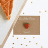 Fève Fraise Baubels en porcelaine artisanale rouge brillante sur carte Les Jolies Fèves
