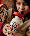 Gourde isotherme pour enfant - Modèle Léopard de Hello Hossy, capacité 350 ml, design tendance avec imprimé léopard sur fond beige. Fabriquée en acier inoxydable, équipée d’un bouchon anti-fuite noir avec anse rouge pour un transport facile. Maintient les boissons chaudes ou froides toute la journée.