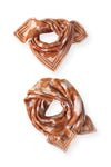 Petit foulard "Manika Flora Bold Orange" de la marque Apaches Collection. Accessoire tendance en tissu léger avec un motif floral vintage dans des tons chauds d'orange et beige. Idéal pour apporter une touche bohème et élégante à votre tenue. Peut être porté autour du cou, dans les cheveux ou en accessoire de sac.