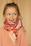 Grand foulard "Latika Joy Macadamia" de la marque Apaches Collections. Accessoire en coton doux avec un imprimé floral aux teintes vives de rouge, violet et orange, sublimé par des bordures beige rayées. Ce foulard polyvalent et tendance peut se porter en bandana, autour du cou ou comme accessoire de cheveux pour un style bohème et élégant.