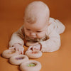 Hochet sensoriel en bois Petit Boum Donut Raisins avec perles violettes et grappes de raisin