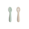 Lot de 2 cuillères d’apprentissage bébé Mushie en silicone souple couleur Cambridge blue et shifting sand