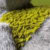 Peluche monstre gris avec détails verts et feuille style créature nature