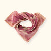 Petit foulard "Manika Bloom Macadamia" signé Apaches Collections. Ce foulard en coton doux arbore un motif floral rose foncé et prune, associé à un imprimé à carreaux beige et rose sur les bordures. Un accessoire de mode chic et tendance, idéal pour sublimer vos tenues avec une touche bohème et raffinée.