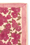 Petit foulard "Manika Bloom Macadamia" signé Apaches Collections. Ce foulard en coton doux arbore un motif floral rose foncé et prune, associé à un imprimé à carreaux beige et rose sur les bordures. Un accessoire de mode chic et tendance, idéal pour sublimer vos tenues avec une touche bohème et raffinée.