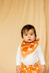 Petit foulard "Manika Flora Bold Orange" de la marque Apaches Collection. Accessoire tendance en tissu léger avec un motif floral vintage dans des tons chauds d'orange et beige. Idéal pour apporter une touche bohème et élégante à votre tenue. Peut être porté autour du cou, dans les cheveux ou en accessoire de sac.