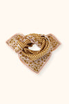Petit foulard "Manika Mosaic Tobacco" de la marque Apaches Collections. Accessoire en coton doux avec un motif mosaïque géométrique et des bordures florales dans des tons tabac et beige. Idéal pour sublimer une tenue avec une touche bohème et chic, ce foulard peut se porter autour du cou, en bandeau ou en accessoire de sac.