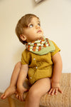 Grand foulard "Latika Pop Corn Olive" de la marque Apaches Collections. Accessoire en coton doux avec un motif original de fleurs et de rayures dans des tons vert olive, orange et beige. Idéal pour ajouter une touche bohème et colorée à votre tenue, il se porte autour du cou, en bandeau dans les cheveux ou en accessoire de sac.
