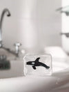 Savon transparent artisanal "Orque" par Ludi Soap. Ce savon unique contient une figurine d'orque en son centre, rendant le moment du bain ou du lavage des mains ludique et agréable pour les enfants. Sa formule douce et hydratante convient aux peaux sensibles. Un cadeau original et amusant pour les petits passionnés du monde marin !