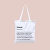 Tote bag "Mamie" de Family Impact Stories, sac en toile blanc avec une définition humoristique de la grand-mère : "Personne ayant une fâcheuse tendance à doubler les portions pendant les repas...". Pratique et original, parfait comme cadeau pour une mamie complice et gourmande.